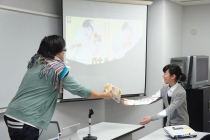 写真：女子中学生にバナシガセットを手渡す山川さん